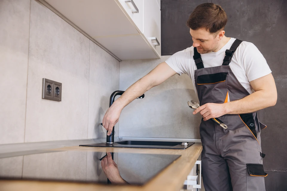 Intérieur de cuisine moderne en cours de rénovation avec placards muraux gris anthracite aux portes vitrées et pleines