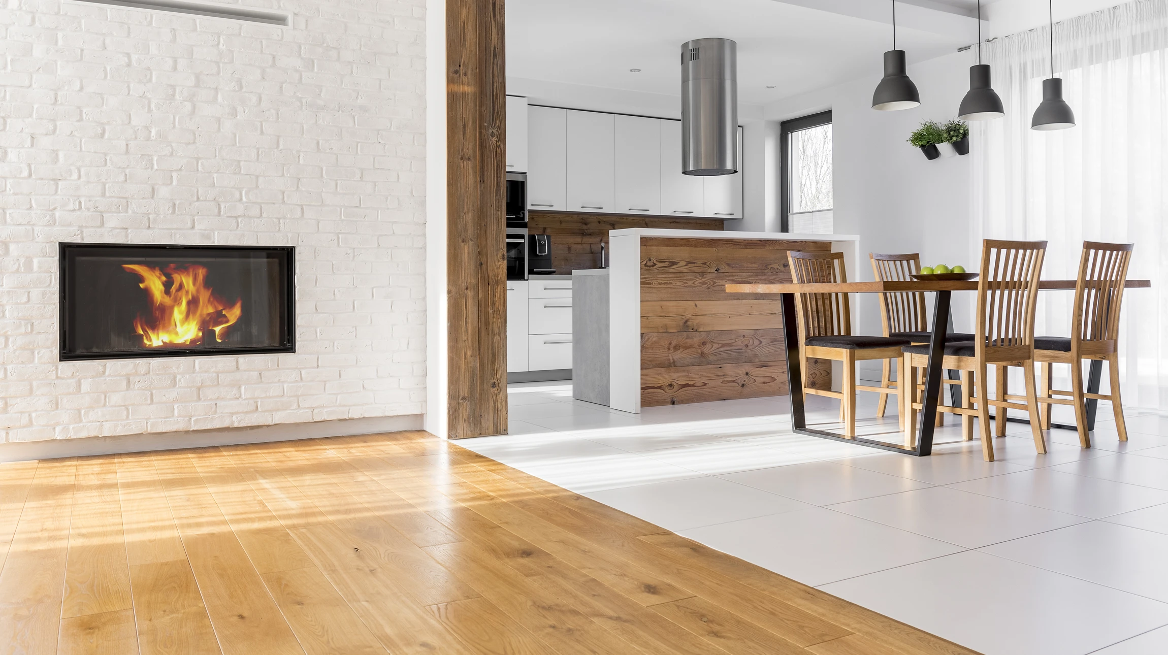 Photographie d'un revêtement de sol nouvellement installé dans un intérieur résidentiel, montrant la transition entre deux types de revêtements contrastants (par exemple, un sol carrelé dans une cuisine adjacente à un sol en vinyle dans le séjour). L'image doit capturer la qualité de la pose, les joints nets, la finition professionnelle, et l'ambiance de l'espace transformé. Plan légèrement en plongée pour mettre en avant la surface du sol et sa texture, lumière naturelle généreuse créant une atmosphère accueillante et chaleureuse.