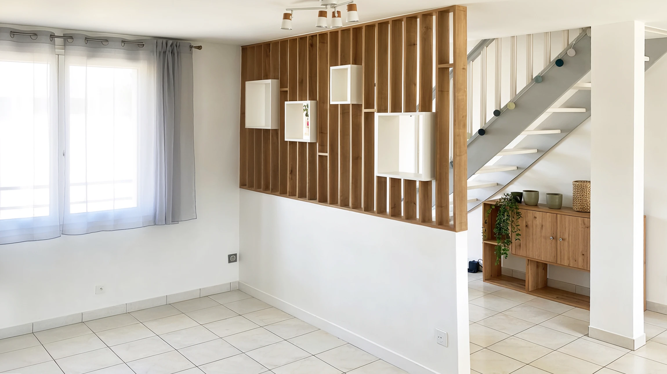 Cuisine moderne &eacute;quip&eacute;e avec plan de travail int&eacute;gr&eacute;, four encastrable avec porte vitr&eacute;e, plaques de cuisson quatre feux, tiroirs de rangement, lave-vaisselle int&eacute;gr&eacute;