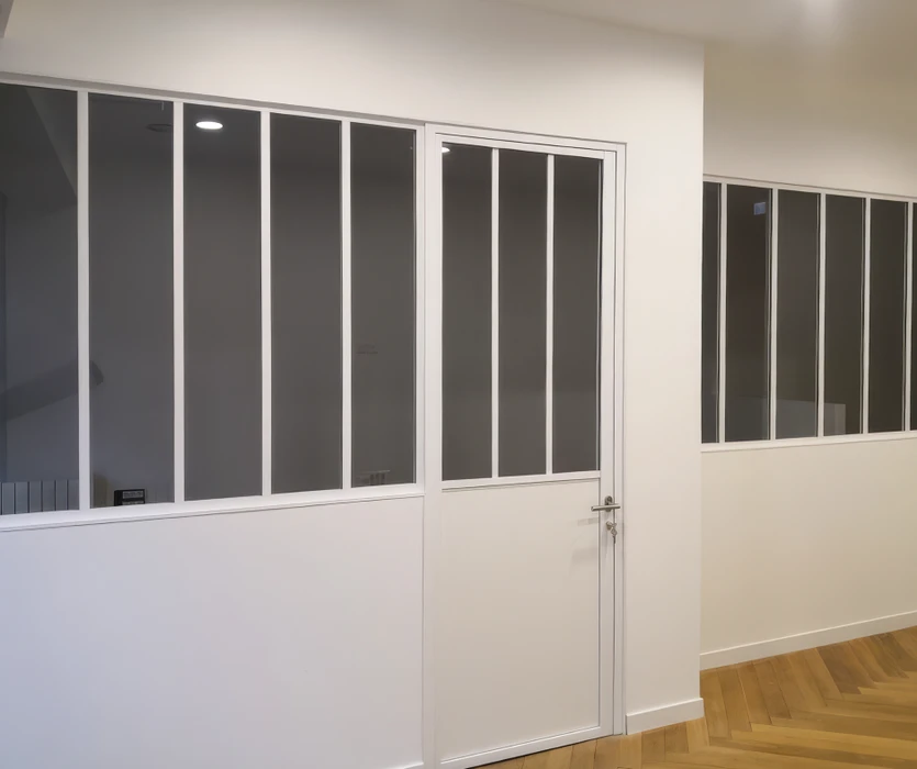 Salon moderne avec mur en lamelles de bois verticales, meuble TV suspendu blanc, bureau intégré et chaise design