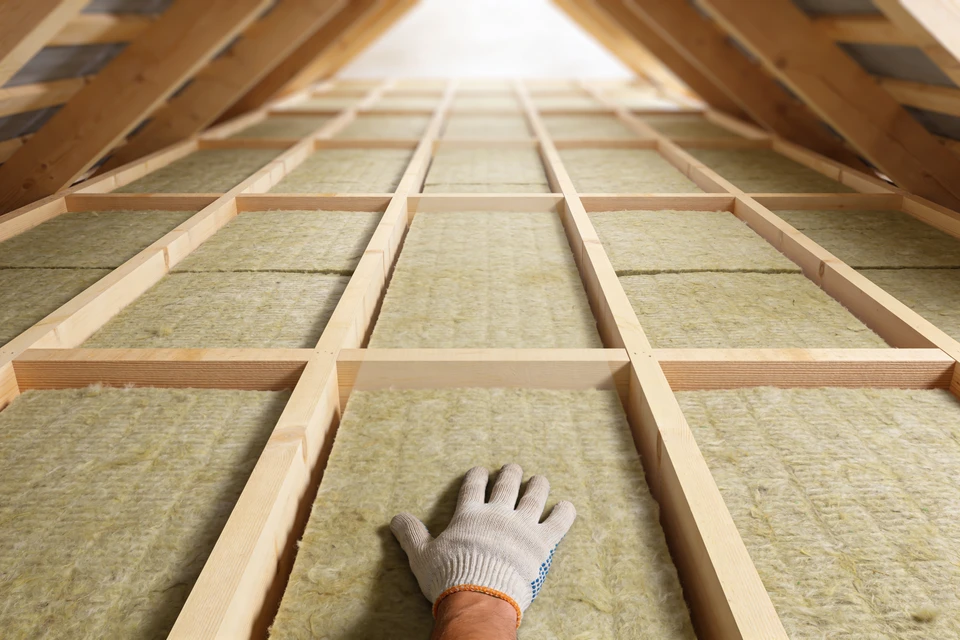 Artisan en combinaison bleue effectuant la pose de carrelage sur plan de travail de cuisine